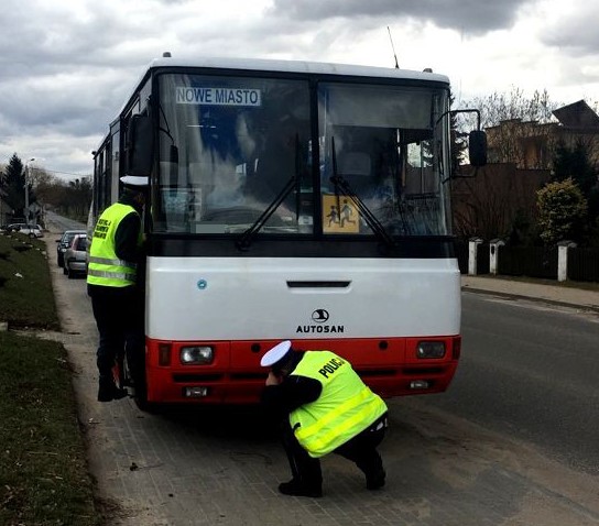 Działania Gimbus - dwóch policjantów ruchu drogowego kontroluje autobus przewożący dzieci i młodzież do szkół