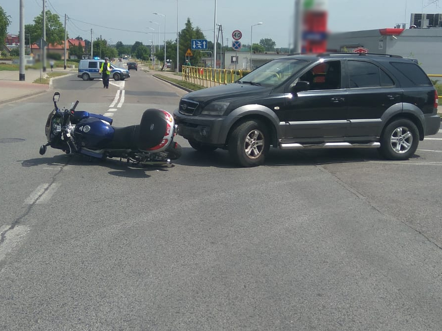 Leżący na drodze motocykl i stojący obok samochód