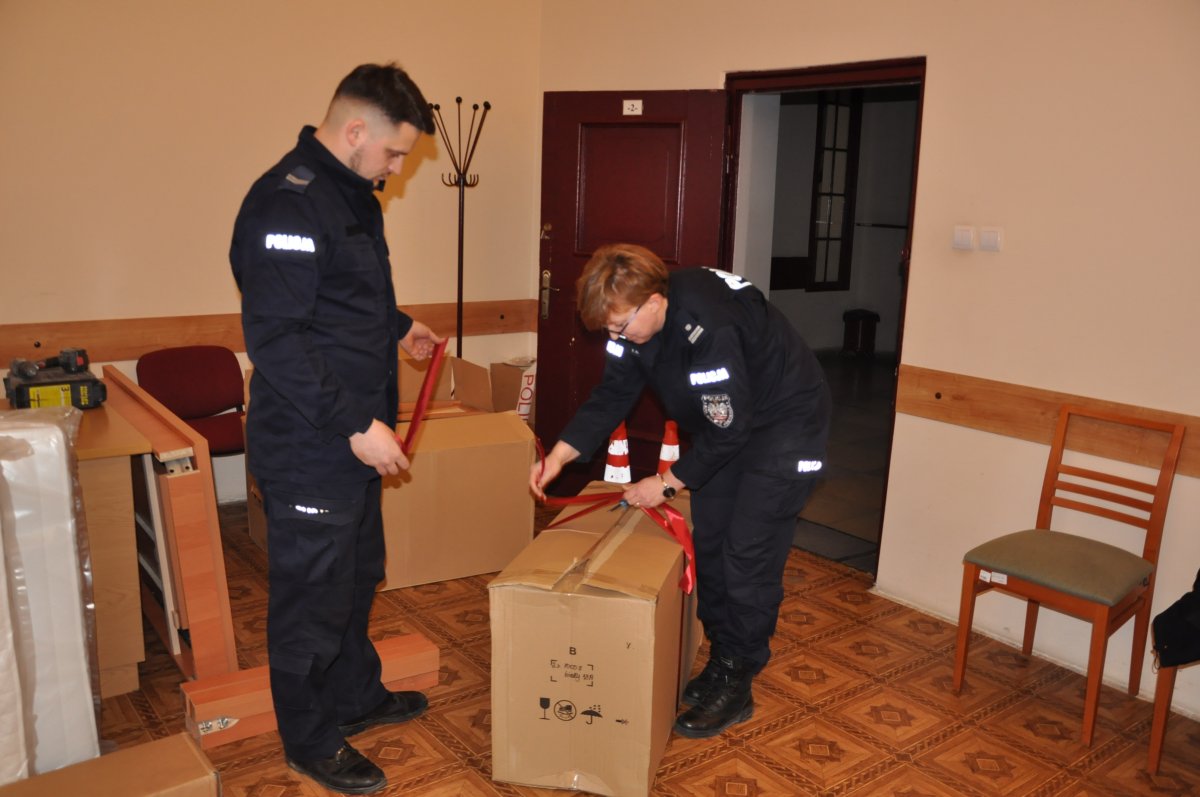 Policjant i policjantka pakują prezenty do kartonów
