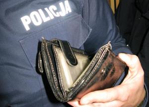 policjant trzyma w ręku portfel