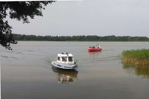 Łódź policyjna i strażacka na jeziorze podczas akcji poszukiwawczej